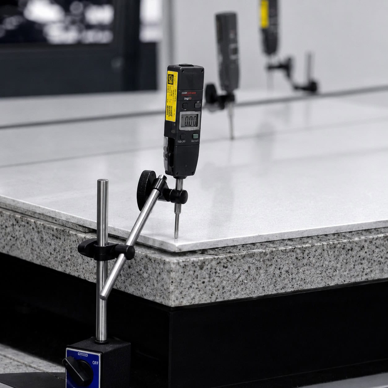 Digital indicator gauge measuring dimensional flatness on an agglomerate tile sample
