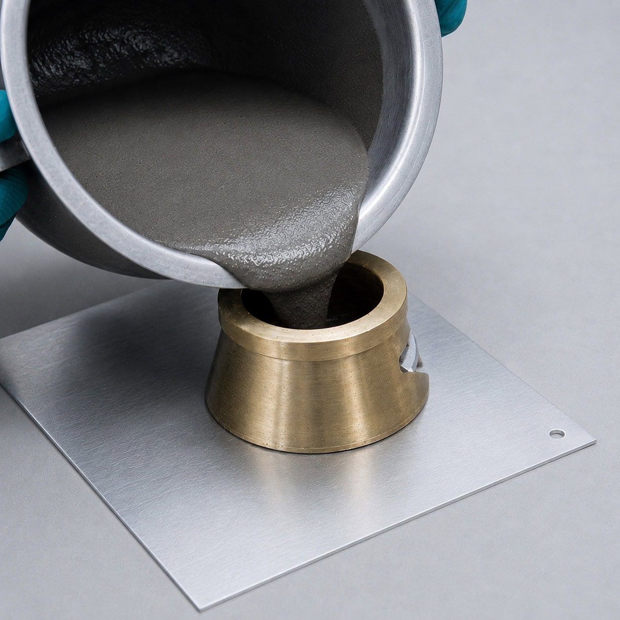 Technician pouring mortar sample into a Vicat cone to test consistency for installation materials